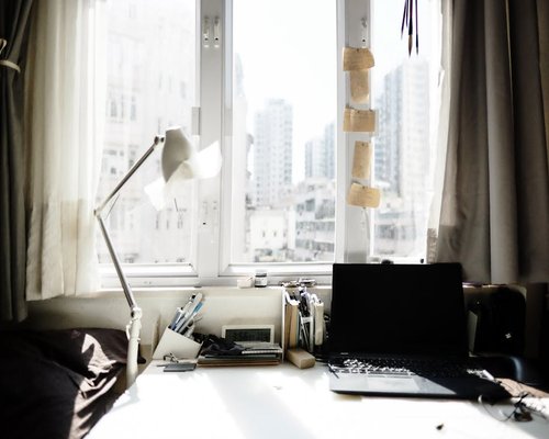A home office desk positioned next to a window with soft natural light
