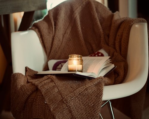 A cozy corner with a reading lamp illuminating a book