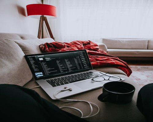 Person typing on laptop with adjusted screen brightness in a cozy room